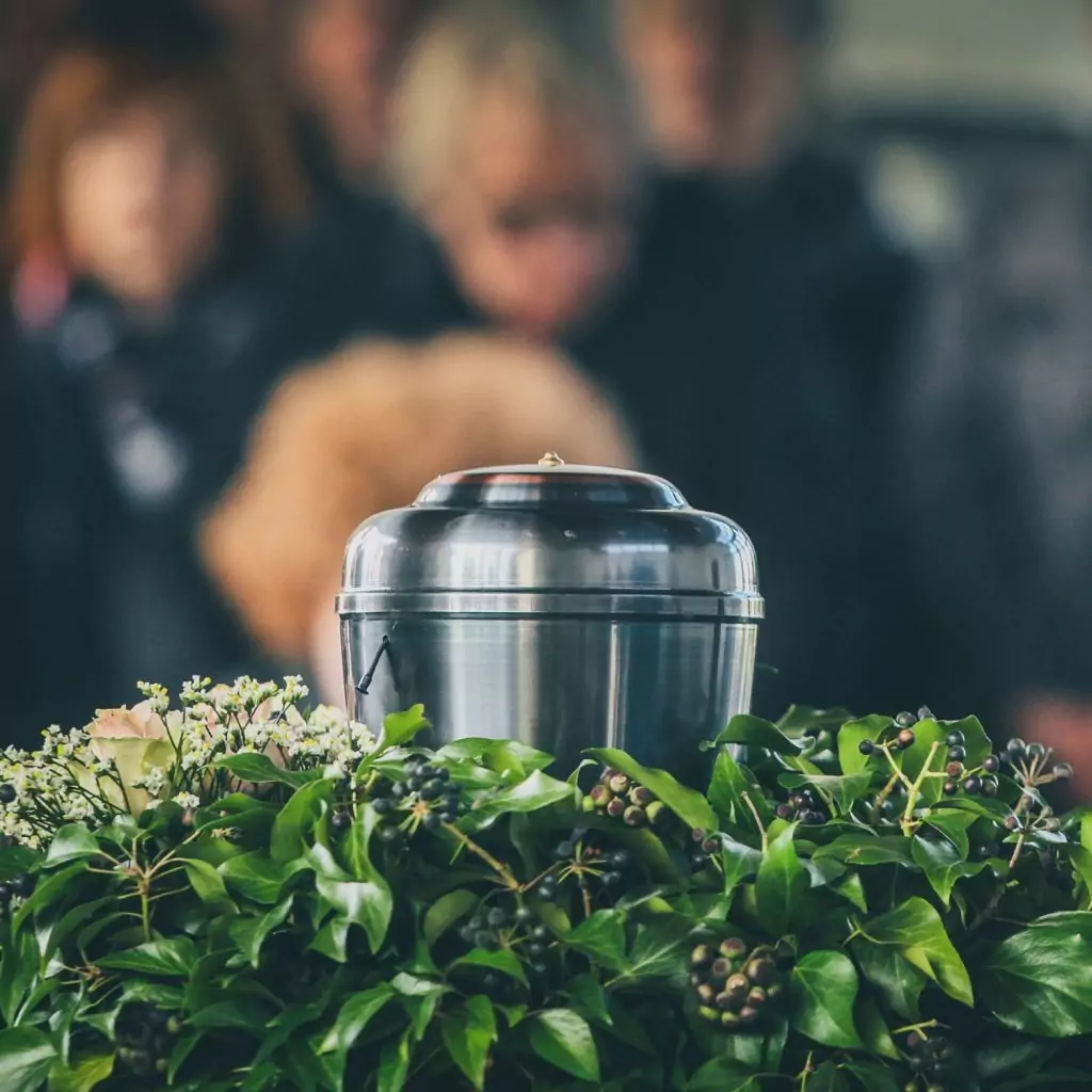 Silberne Urne mit Blumenschmuck bei einer Trauerfeier