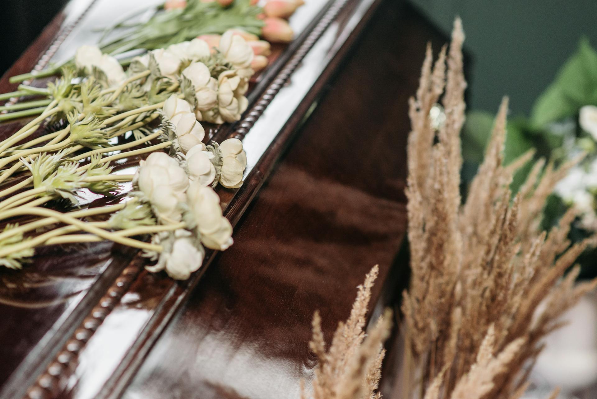 Nahaufnahme eines Sargs mit Blumen darauf